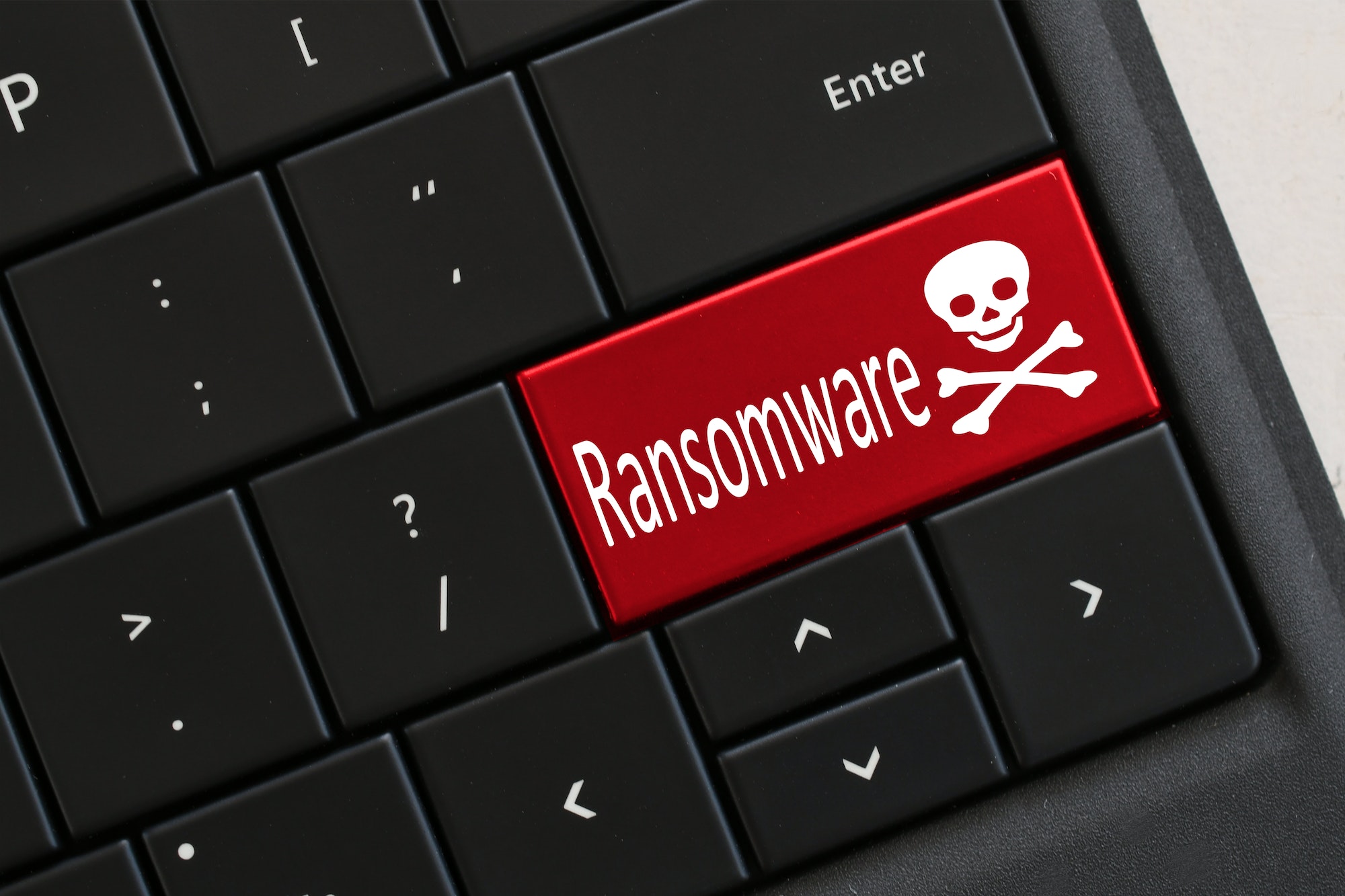Ransomware concept Computer Keyboard with red RANSOMWARE skull crossbones Hacked virus cyber attack